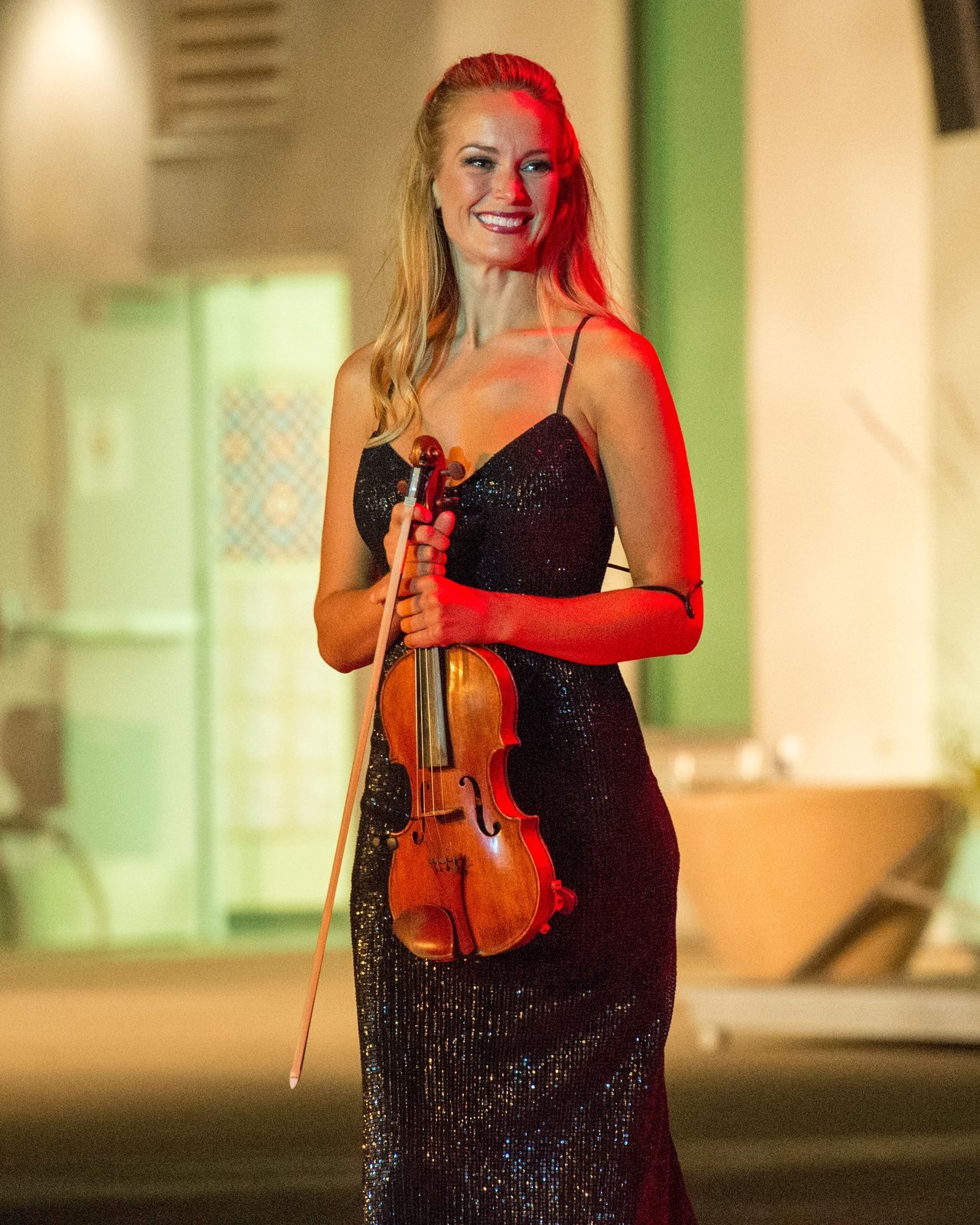 A violinist in a black sequined dress holding her violin