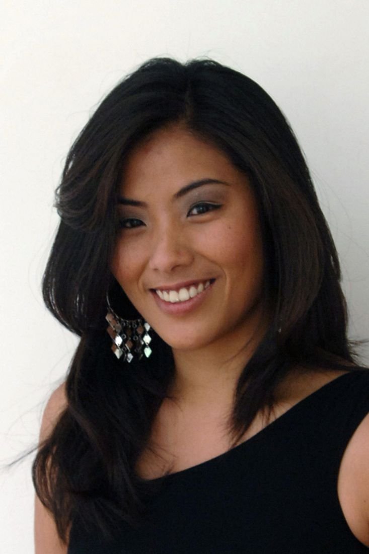 Portrait of a smiling woman with long dark hair and drop earrings